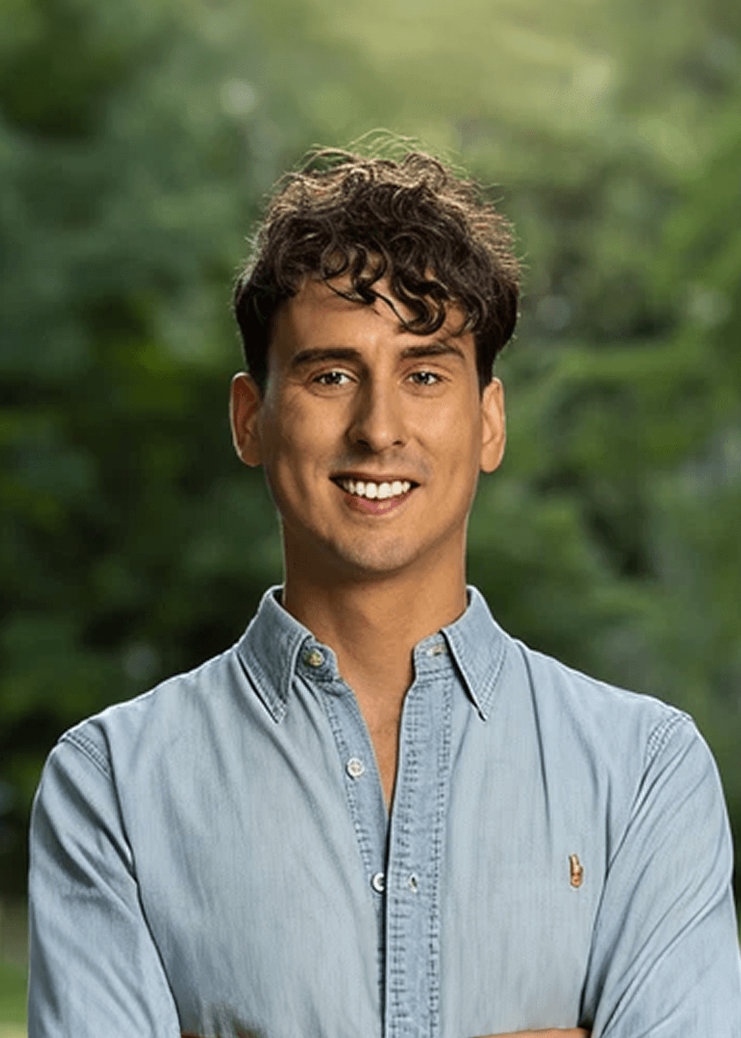 Black and white portrait of a smiling person with curly hair